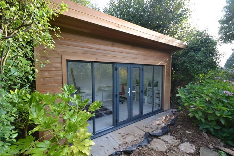 This garden room, used as an art studio, has wide powder coated aluminium doors and windows