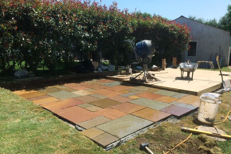 The sandstone patio with stone retaining dwarf wall is laid