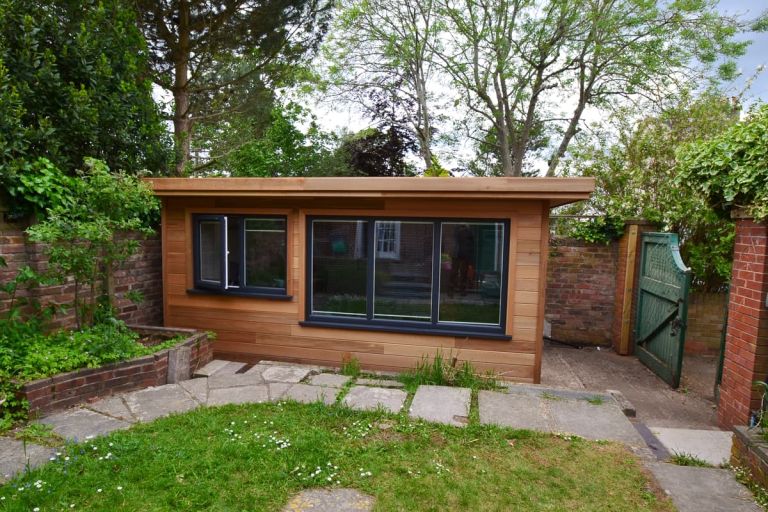 Bespoke garden office in Exeter. Western red cedar TGV cladding boards with matching soffits, fascia, and corner trims. UPVC doors and casement windows coloured anthracite grey