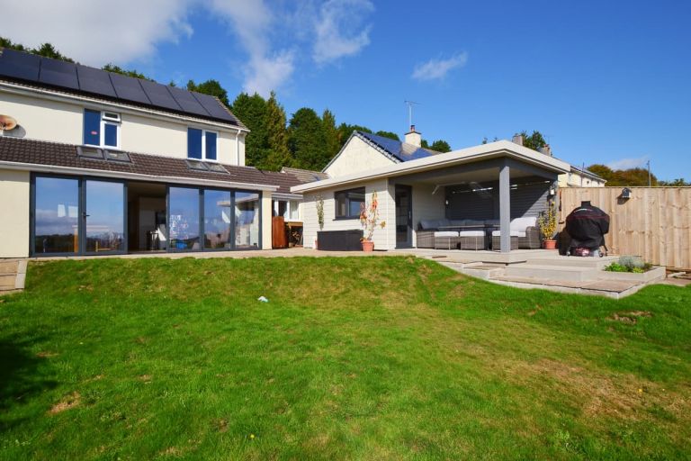 Looking from the garden towards the back father house and the garden room. The James Hardie cement composite cladding boards blend with the style of the house