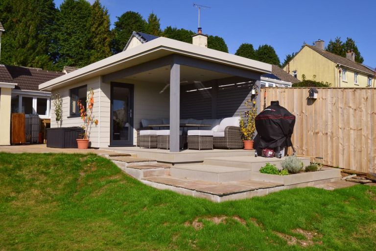 A bespoke garden room with an extended roof canopy with recessed spotlights