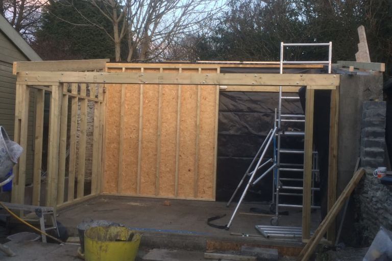 Exterior walls made of timber are erected for this garden room/artist studio in Aveton Gifford