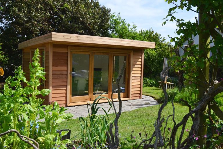 The garden room is built in an AONB in South Milton, Devon. It has solid oak doors and windows and is clad in Western Red Cedar