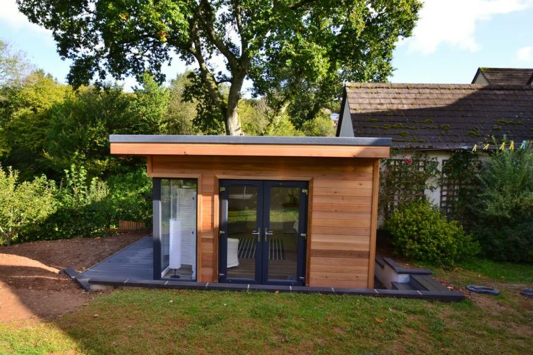 The side elevation showing Western red cedar cladding, and grey windows and doors