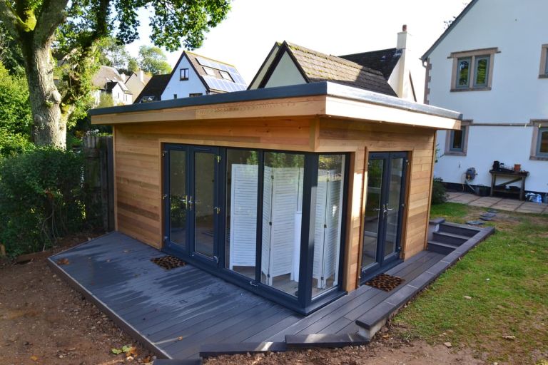 Garden room in Totnes used as an office, studio and den. There is composite decking around building, leading out from dual-aspect glazing