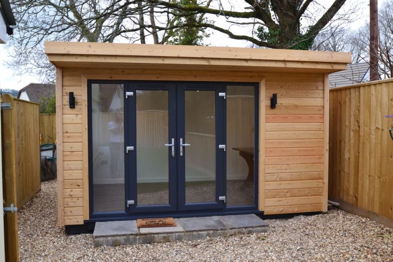 A garden room with larch TGV cladding and external down and up lights