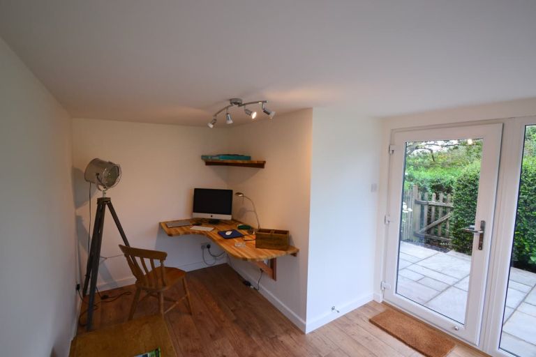 Inside the garden room. The desk area is positioned behind the area for the discrete storeroom