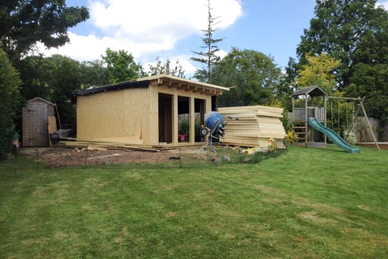 The walls have been constructed. A pile of 100mm Cellotex insulation waiting to be installed