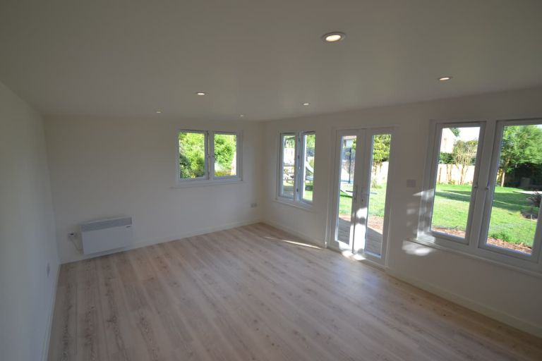 The interior of the treatment room looking through the UPVC doors and casement windows to the garden beyond